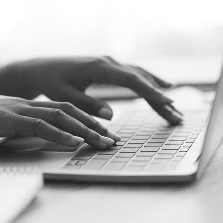 Hands typing on laptop keyboard