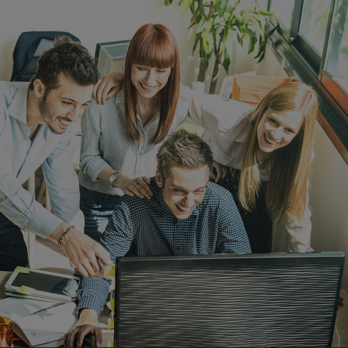 Two men and two women gathered around computer screen